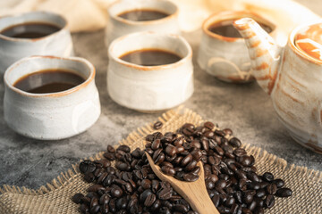 Black Coffee in Japanese kettle and coffee beans with wood spoon on Old Table.