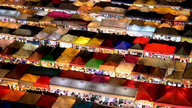 Ratchada Rot Foi Train night market in Bangkok, Thailand with rows of colourful tents stalls seen at night