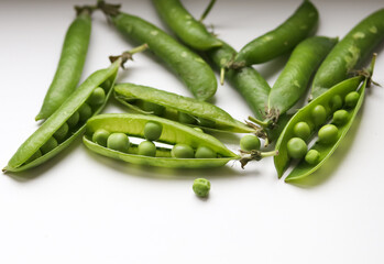 green pea pods on a light background close up