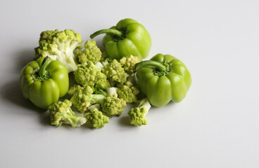 romanesco cabbage and green peppers on a light background close up