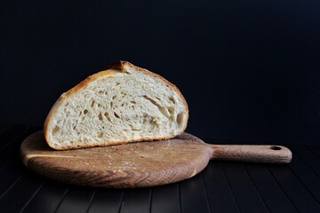 Slice of sourdough bread on cutting board. Artisan bread crumb texture. Homemade bread food...