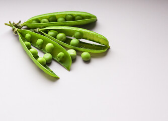 green pea pods on a light background close up