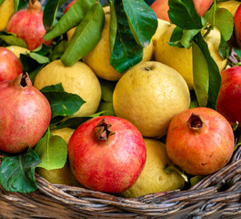 Lemons and pomegranate in a basket. Selective focus.