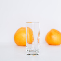 Glass with grapefruit juice and whole and sliced grapefruit on the background