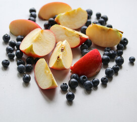 cut fresh apples and ripe blueberries on a white background close up