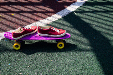 red women's sneakers and a skateboard on the playground
