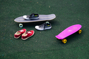 red sneakers and gray sneakers and skateboards on the sports ground