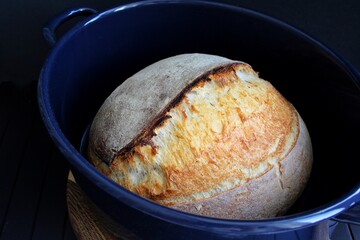 Sourdough bread In blue pan on black background. Homemade bread food photography. High quality illustration