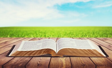 Open vintage christian bible on wooden desk