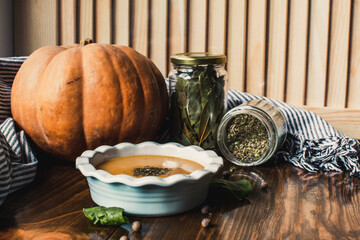 Pumpkin and carrot cream soup on the dark wooden table. Healthy food.