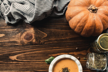Pumpkin and carrot cream soup on the dark wooden table. Healthy food.