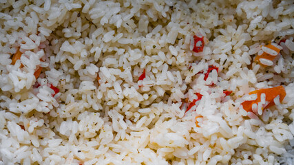 Macro photo of cooked white rice with carrots, red pepper and spices