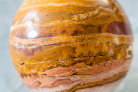 Brecciated Jasper multicolored polished crystal spheres on gray background, semiprecious stone balls for meditation, selective focus close up