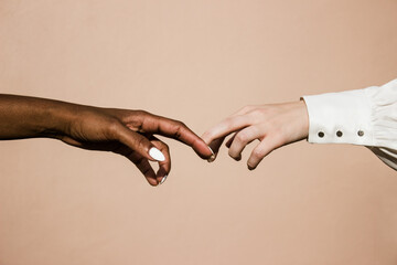 white and black hands reaching towards each other 