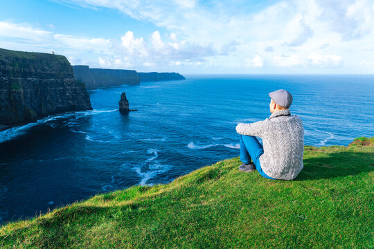 Man looking at cliffs of moher in Ireland