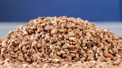 Essential goods: Buckwheat. Buckwheat seed pour in bunch closeup. Buckwheat cereal background.