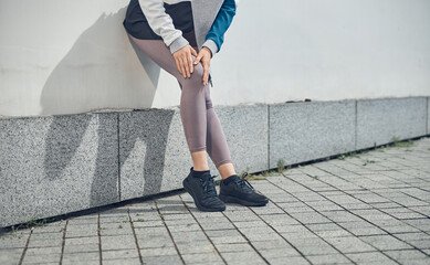 Female athlete examining her injured leg outdoors