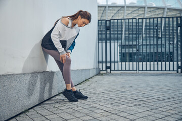 Professional female runner suffering from a kneecap injury