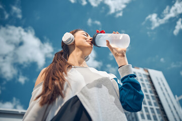 Young dark-haired woman holding a plastic bottle