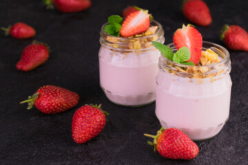 
Strawberry yogurt with granola on a black background.