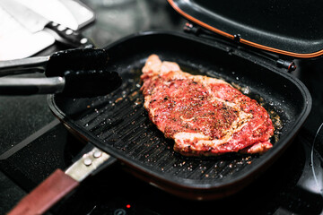 Chef preparing dry-aged beef, Sirloin with truffle oil, garlic, and black pepper seared in juicy...