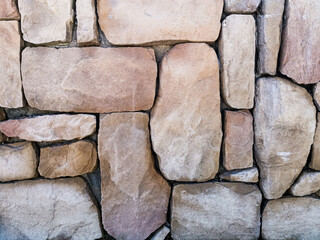 The texture of large stones in beige tones. Abstract stone wall background for designers. Front...