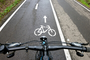Bicycle on a bike path in a summer forest. Bicycle lane signage on a street. Focus on the middle ground