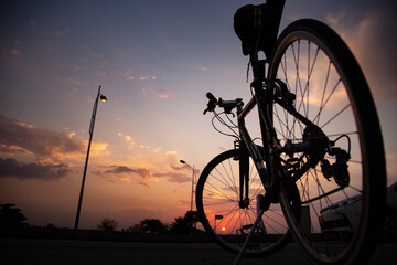 Silhouette of a bicycle with clouds and sunset in the background