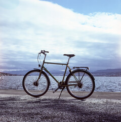 Fototapeta na wymiar A bike standing by the lake of Zurich, shot with analogue slide film technique
