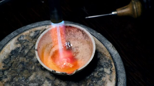Molten gold. Master jeweler makes gold jewelry. Jewelry workshop.