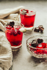 Close-up on glass cup berry fruit jelly pudding with fresh raspberries - summer dessert  in glasses on gray background