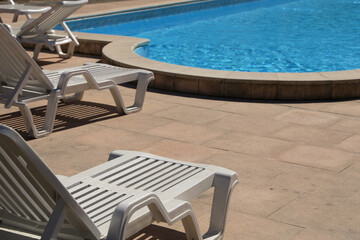 Fototapeta premium white plastic deck chair by the pool