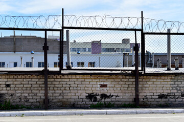 Fototapeta premium Factory zone barbed wire fence and buildings