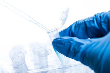 gloved hand and laboratory test tubes in a laboratory. virus or vaccine testing