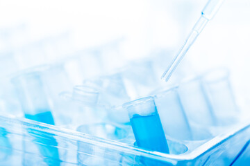 microbiological pipette in the genetic laboratory. study of a virus or vaccination. blue tinted.