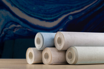rolls of multi-colored paper wallpaper on a wooden table
