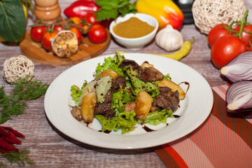 Salad with meat and pears on a white plate