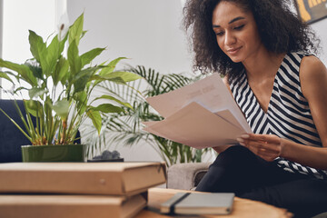 Concentrated woman analyzing the documents at the desk