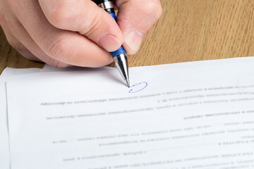 Man's hand signs a contract. Agreement, deal, business concept.