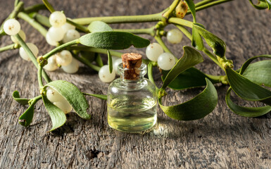 Essential oil bottle with fresh mistletoe twigs