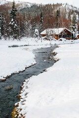 Snow Covered Log Cabin Beside Creek,CChena Hot Springs,Alaska,USA