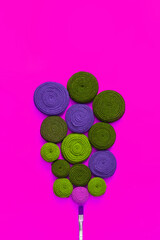 Paint brush and rolls of fabric stripes on a magenta background. The fabric stripes are made of old wears. The concept of upcycling and zero waste.