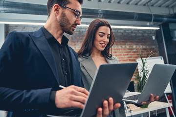 Happy business people looking at laptop screens