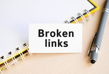 Broken links - text on a notebook with a spring and a gray handle