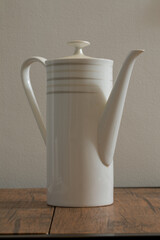 White teapot for tea on a wooden table