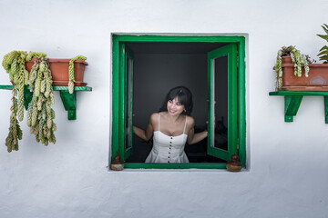 Happy ethnic lady opening window