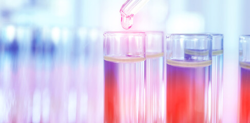 Dripping liquid into test tube on blurred background, banner design. Laboratory analysis