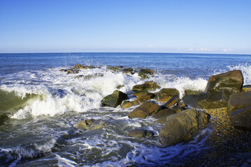 Waves breaking on stones, seashore