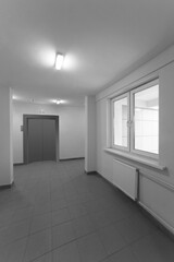 Entrance hall of residential building. Elevator doors and windows.