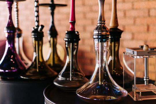 Hookahs in an assortment of different shapes and colors, side view, beautiful transparent glass, high-quality metal